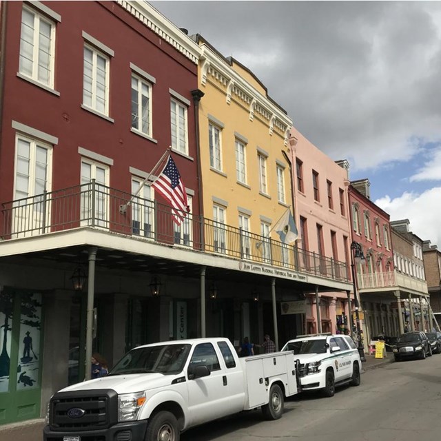A 3-story building (red on the left side and yellow on the right side) with a balcony in front