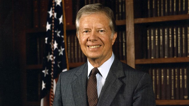 Portrait of Jimmy Carter with hand resting on a globe