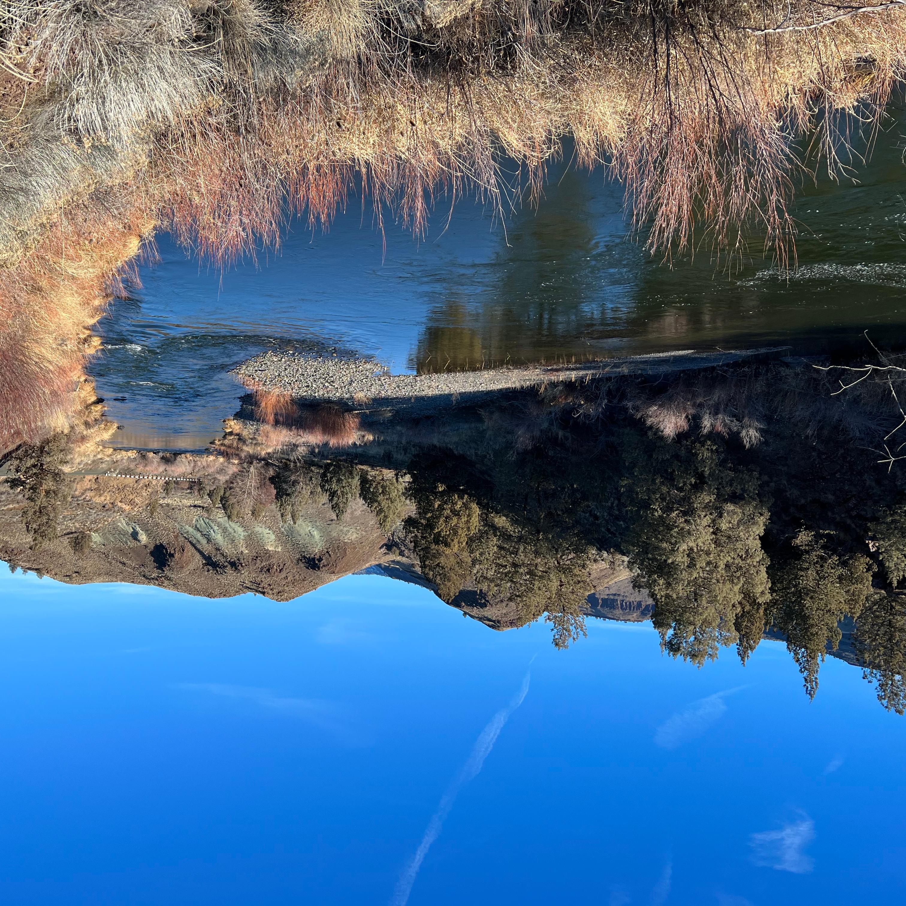 A river with a road running parallel to it.