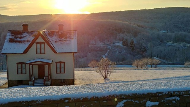 An 1880s farmhouse with the dam abutments in the snow.