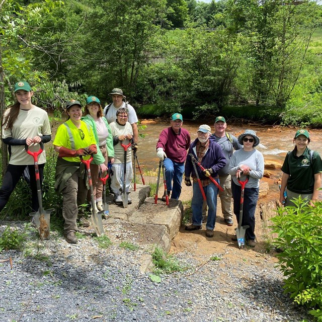 A group of volunteers in the lakebed with the creek behind them.