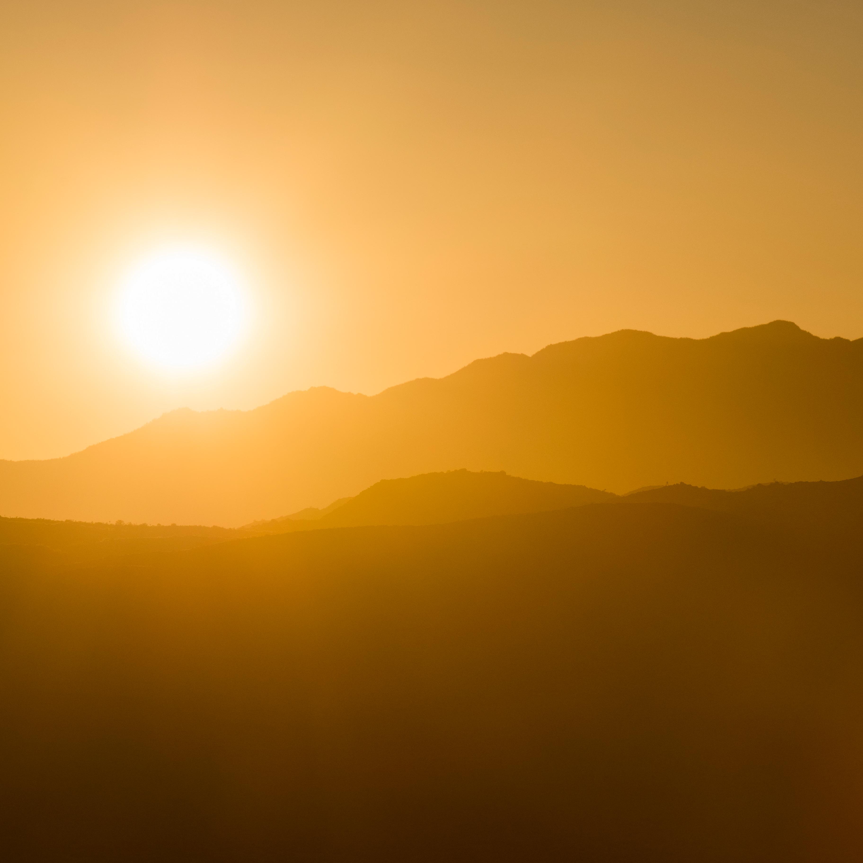 A sunsetting over silhouetted mountains.