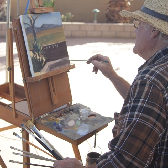 A painter works on a plein art landscape of Joshua Tree.
