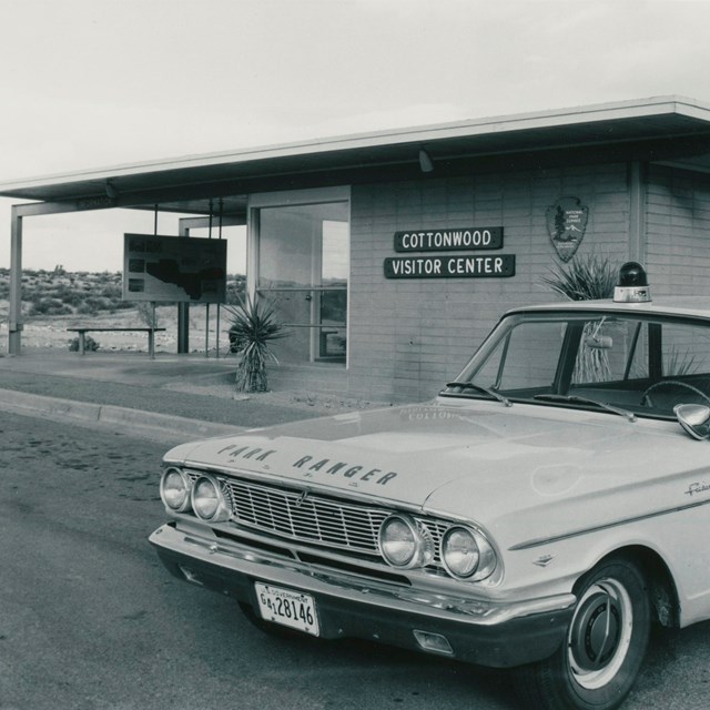Black and white photo of historic building and car.