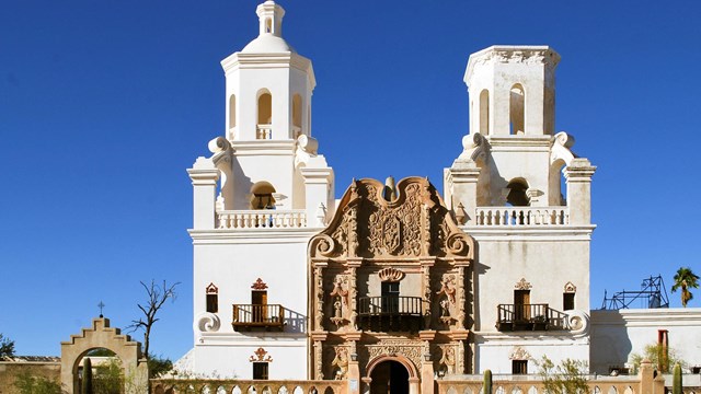 A large white church with Spanish architecture in a desert landscape