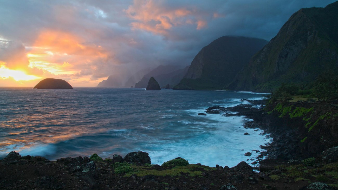 Sunrise over the ocean, two islands, and sea cliffs. 