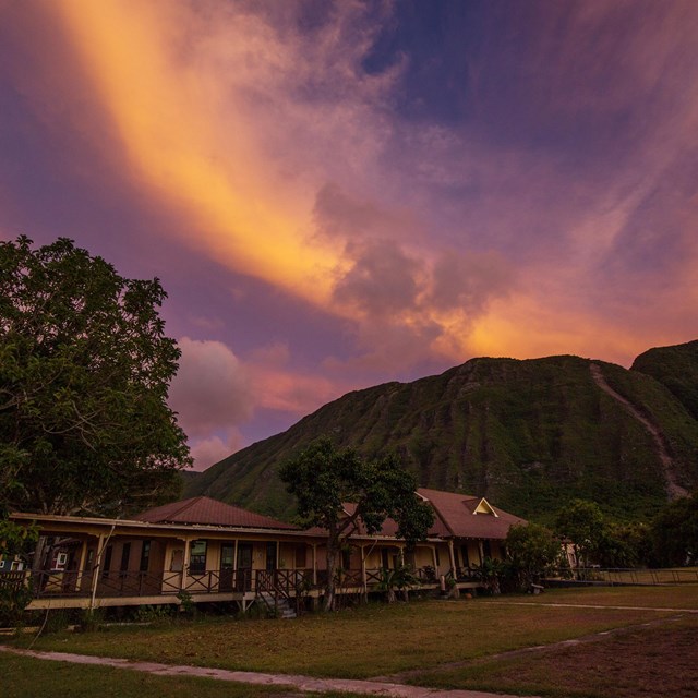 A building and lawn under a vibrant sunset