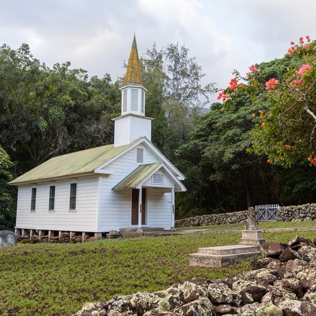 A white church building with a steeple. 