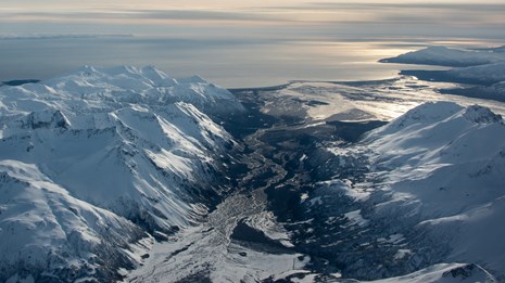 Arial view of a bay with snowy mountains and braided river area