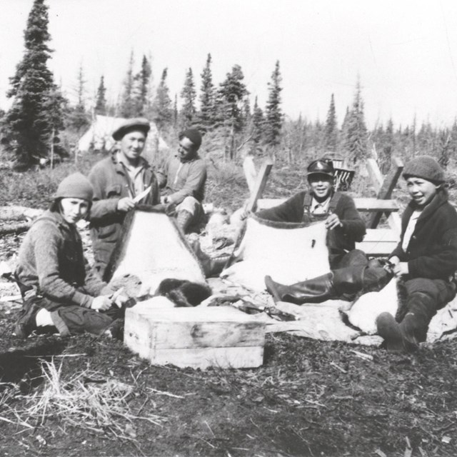 A historic photo of six people at a camp site.