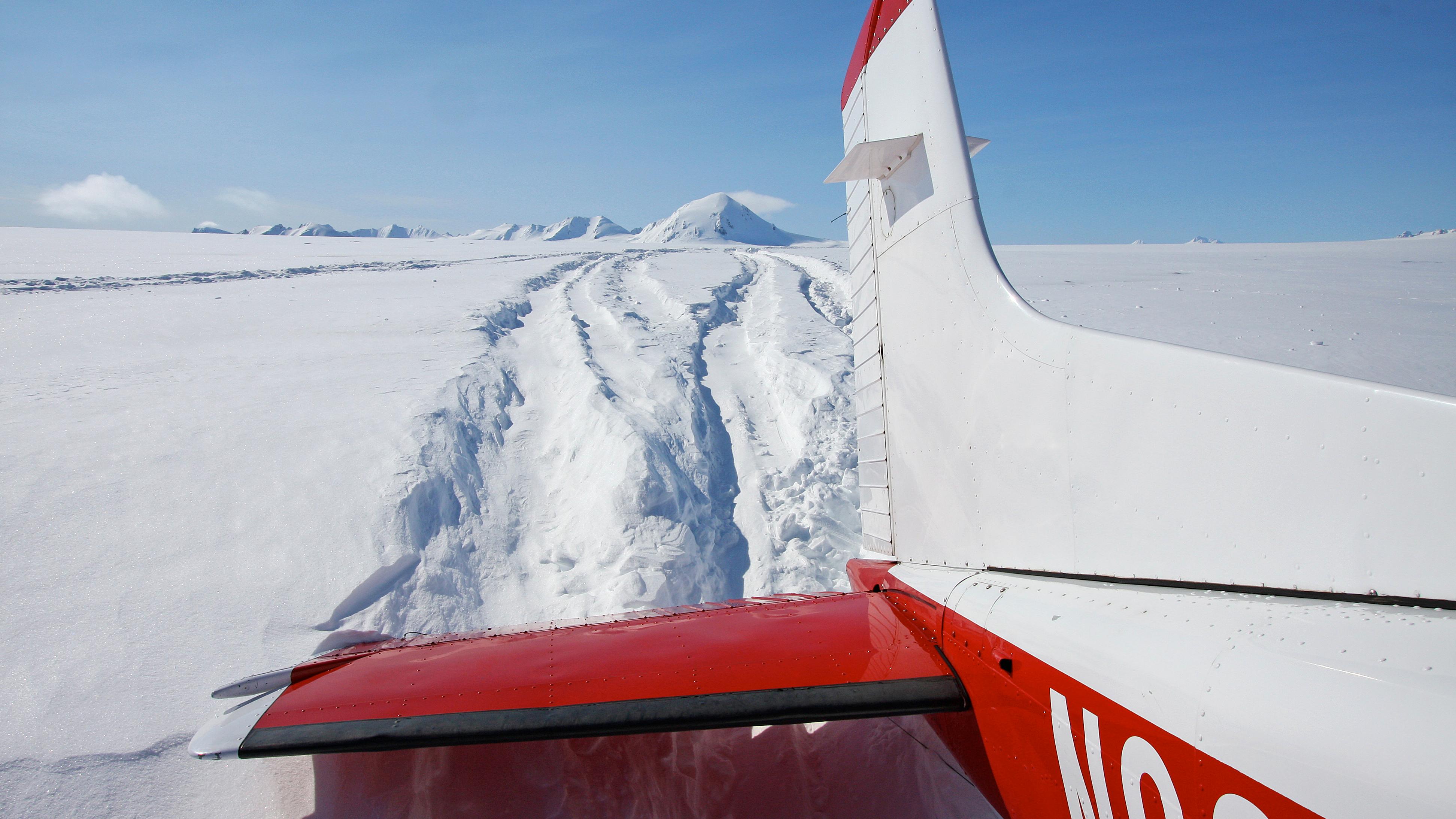 The tail of a small plane landed on snow