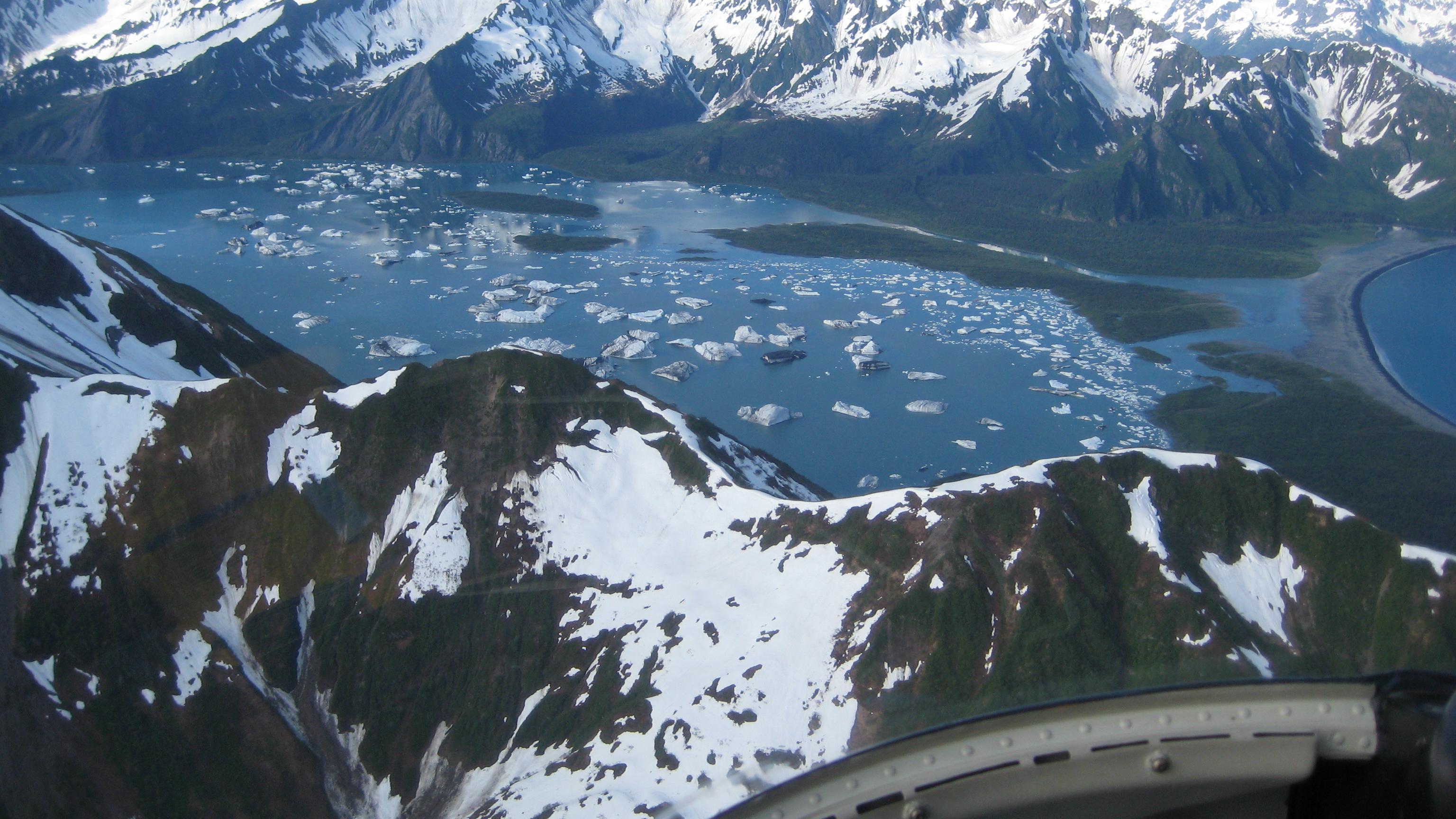 Aerial view of icebergs in a glacial lagoon surrounded by mountains