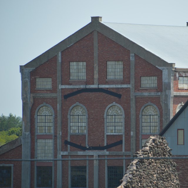 A large red brick building formerly used to extract miners and materials from deep shafts. 