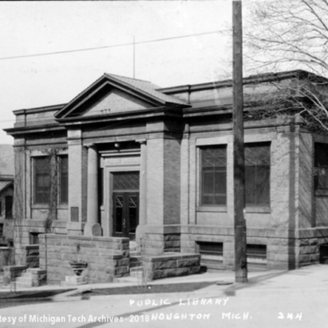 A historic black and white photo of a brick building in Houghton, Michigan.