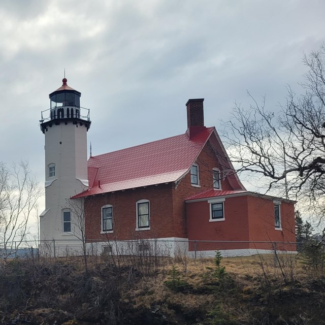 Lake Superior breaks on the rocks below Eagle Harbor Lighthouse on a cloudy day