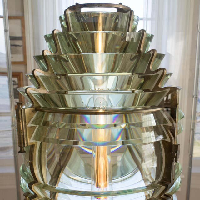 yellow light shining through a stack of clear glass lenses