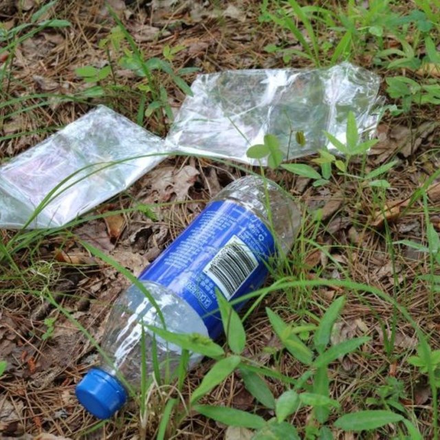 Litter including bottles and plastic on the ground.
