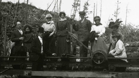 A group of people sit along railroad siding