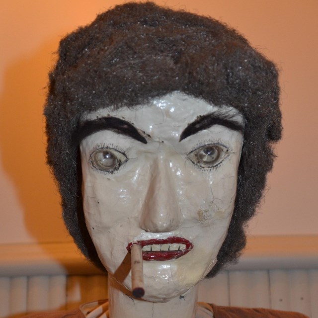 Close up of female manikin head with cigar in mouth