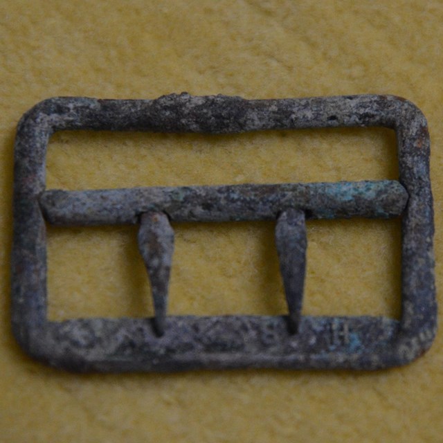Metal buckle with green corrosion 