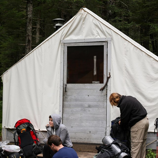 People in front of a canvas tent