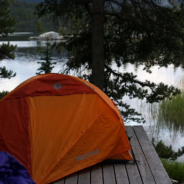 A tent in front of a mountain lake