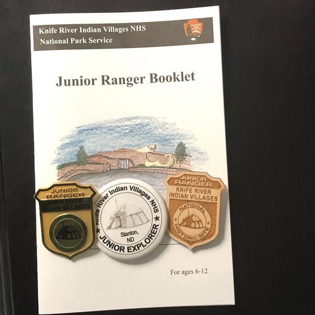 Jr Ranger booklet with three badges on it.