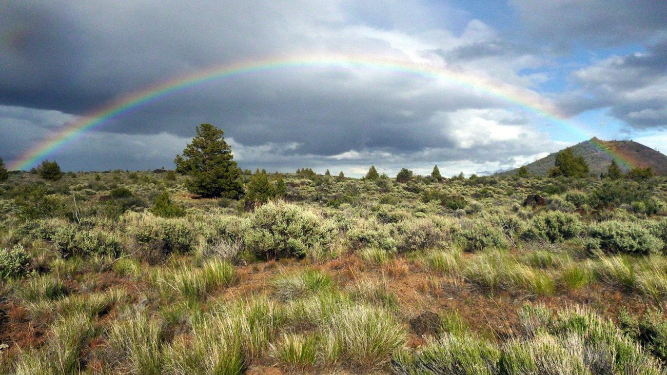 Rainbow over lava beds landscaped covered in sagebrush