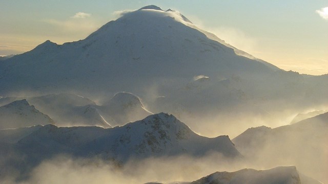 Mist rises from ridges leading to the Redoubt Volcano