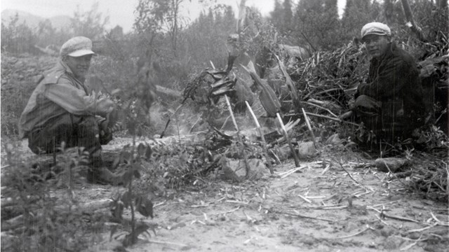 Black and white photo of two men with salmon backbones and beaver feet taken in the early 1940s.