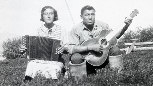 Historic image of woman playing accordion and man playing guitar.