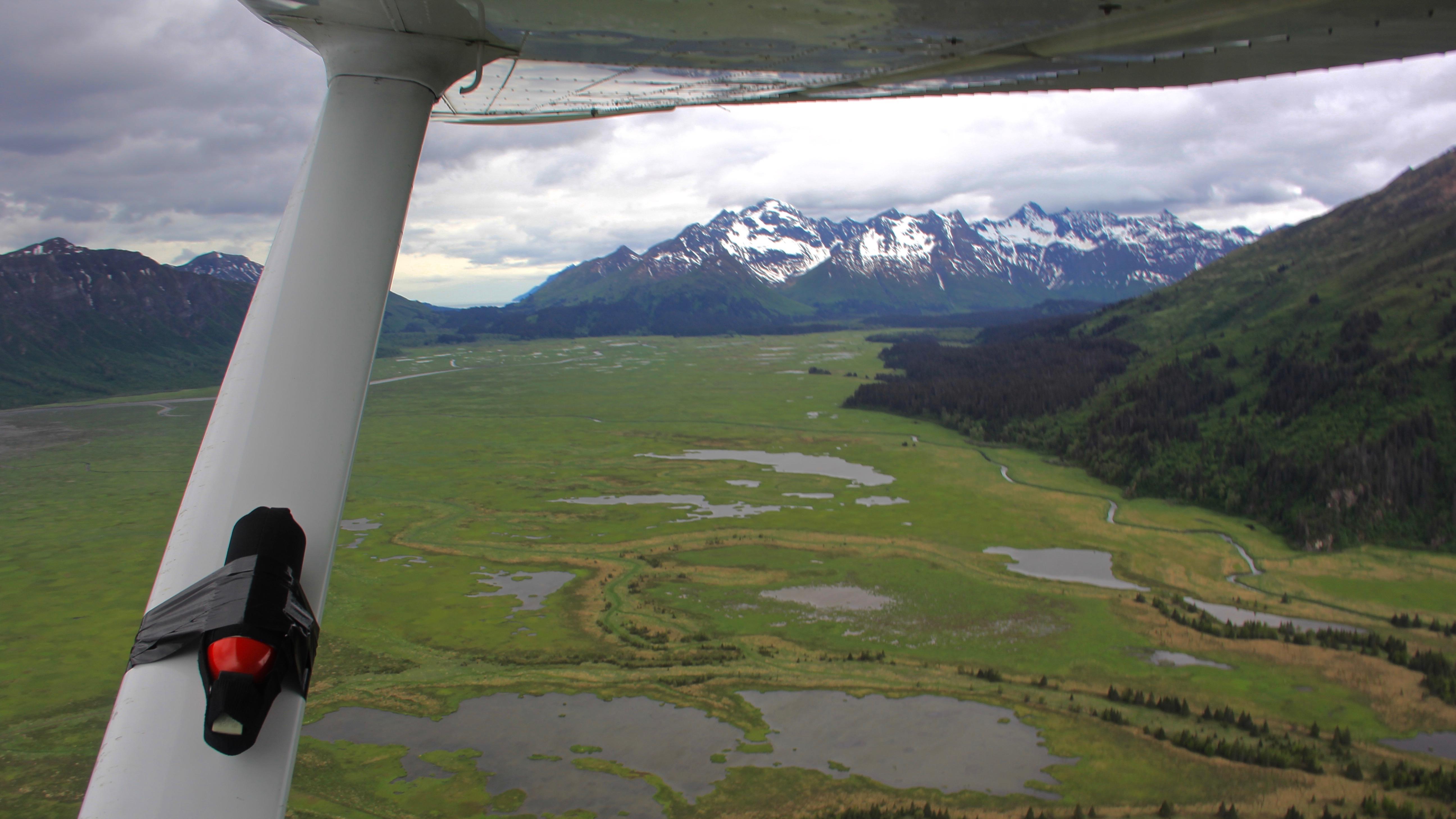 bear spray duct taped to a plane strut and an aerial view 