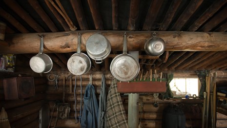 Pots and pans hang from a cabin wall