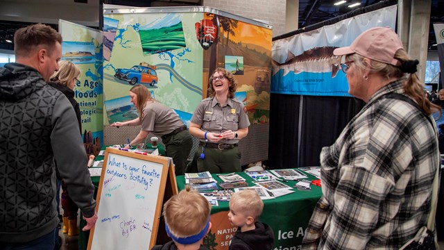 Two rangers interact with visitors at an outreach event