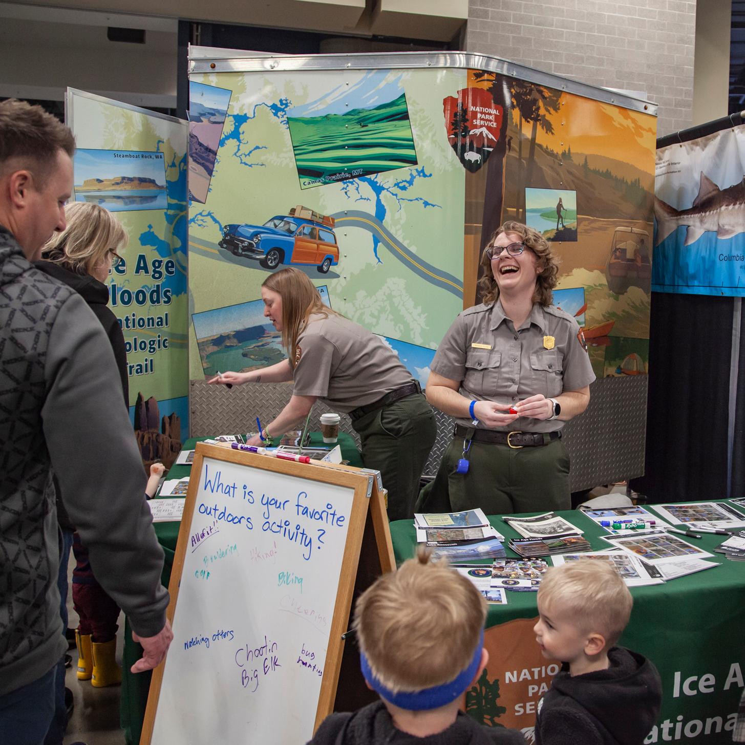 Two rangers interact with visitors at an outreach event