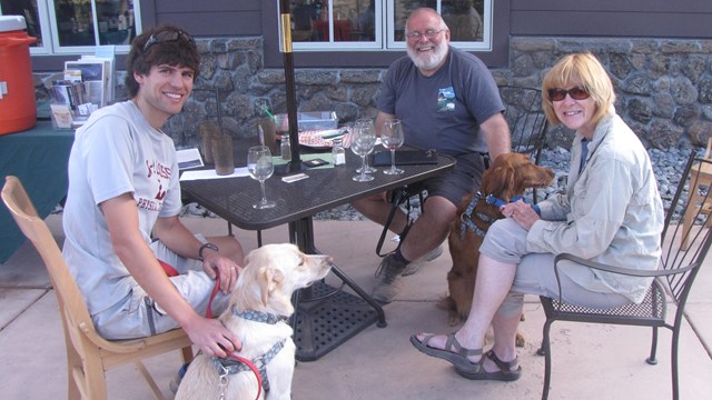Visitors with leashed dogs at table 
