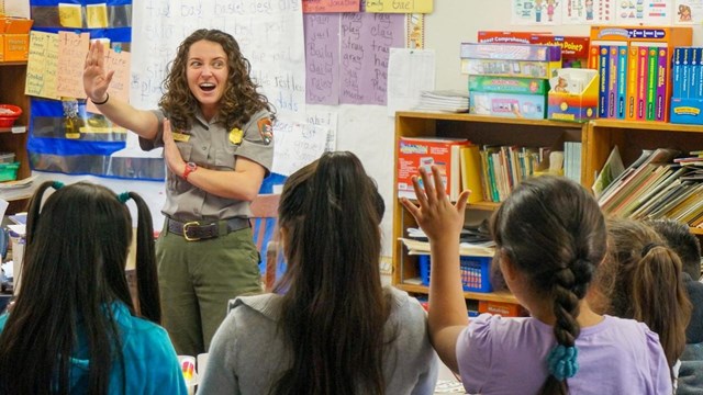 ranger gesturing while presenting to students in a school classroom