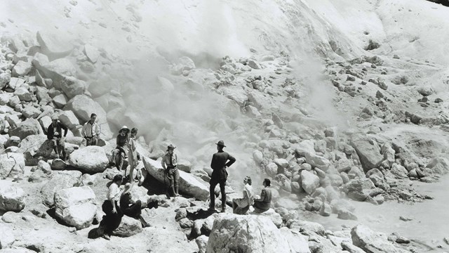 historic photo, park ranger talking to group at hydrothermal feature