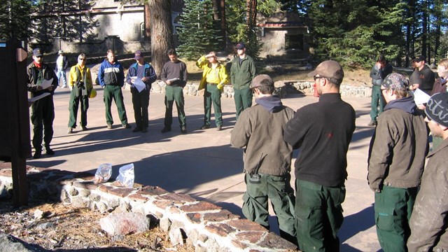 group of people holding printed agendas and talking