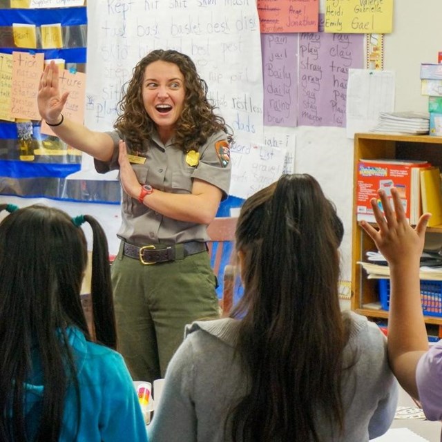 ranger gesturing while presenting to students in a school classroom