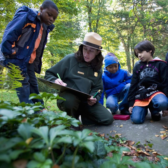 Park ranger drawing a picture for kids in the forest