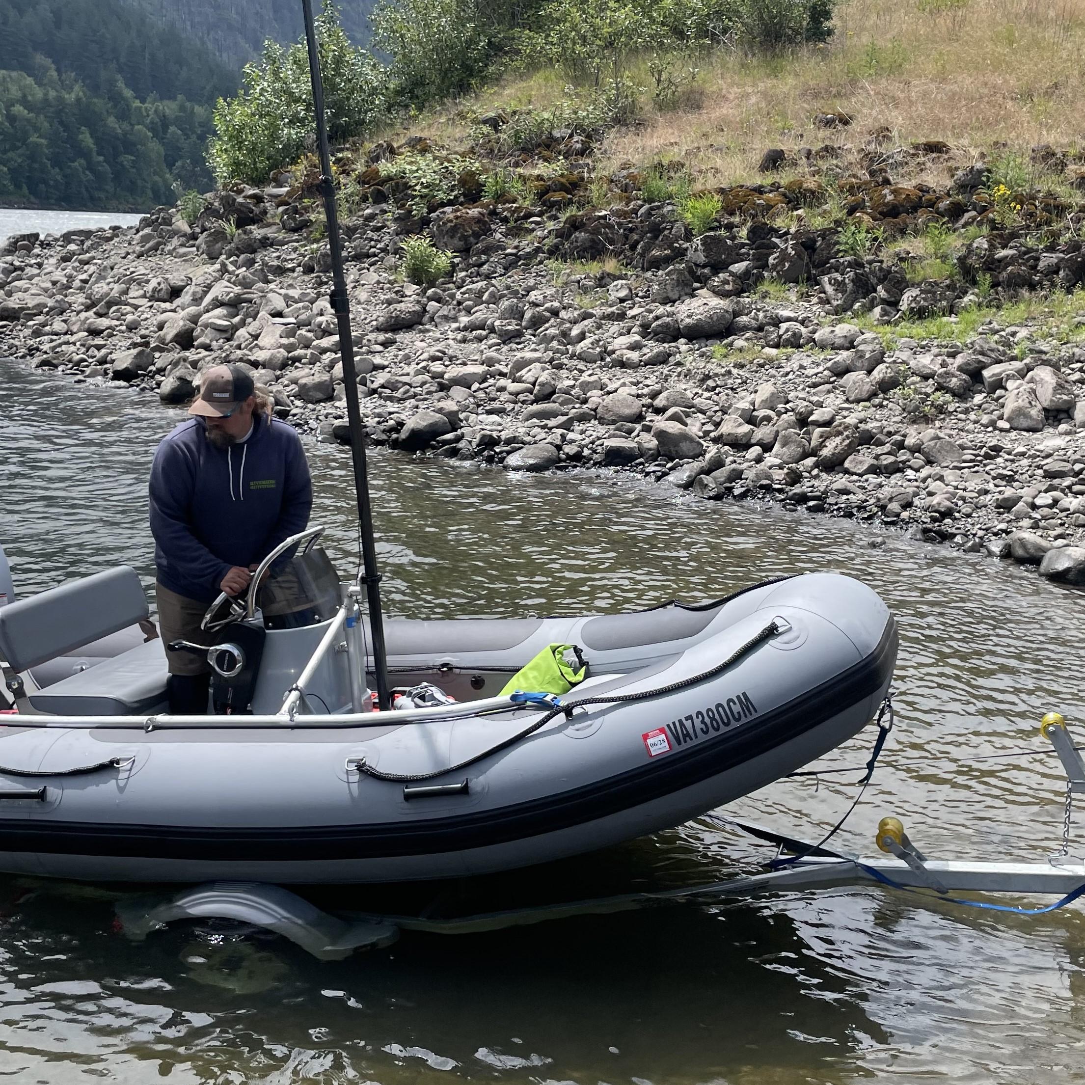 two men load a boat on a river