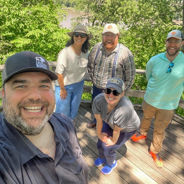 five people wearing hats in a forest