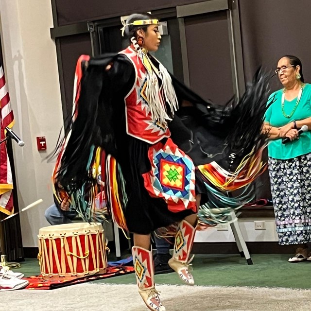 a woman in ceremonial clothes dances