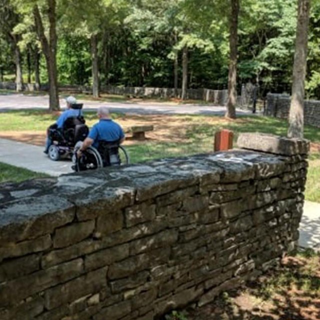 two wheelchairs on path to parking lot 