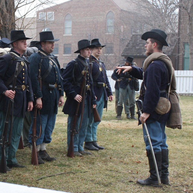 Photo of Civil War union soldier reenactors, wearing dark blue union coats and hats