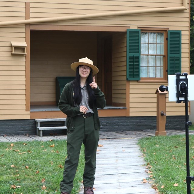 Ranger standing in front of a tablet with the Lincoln Home in the background