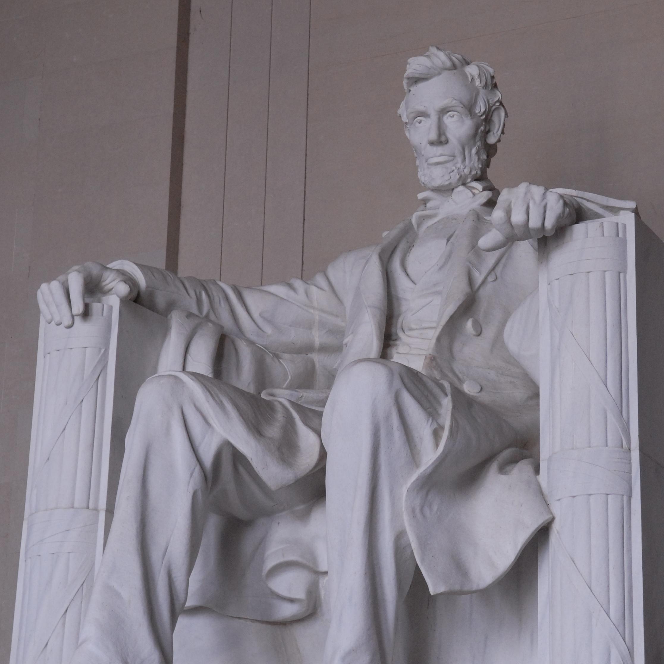 A marble statue of Abraham Lincoln seated.