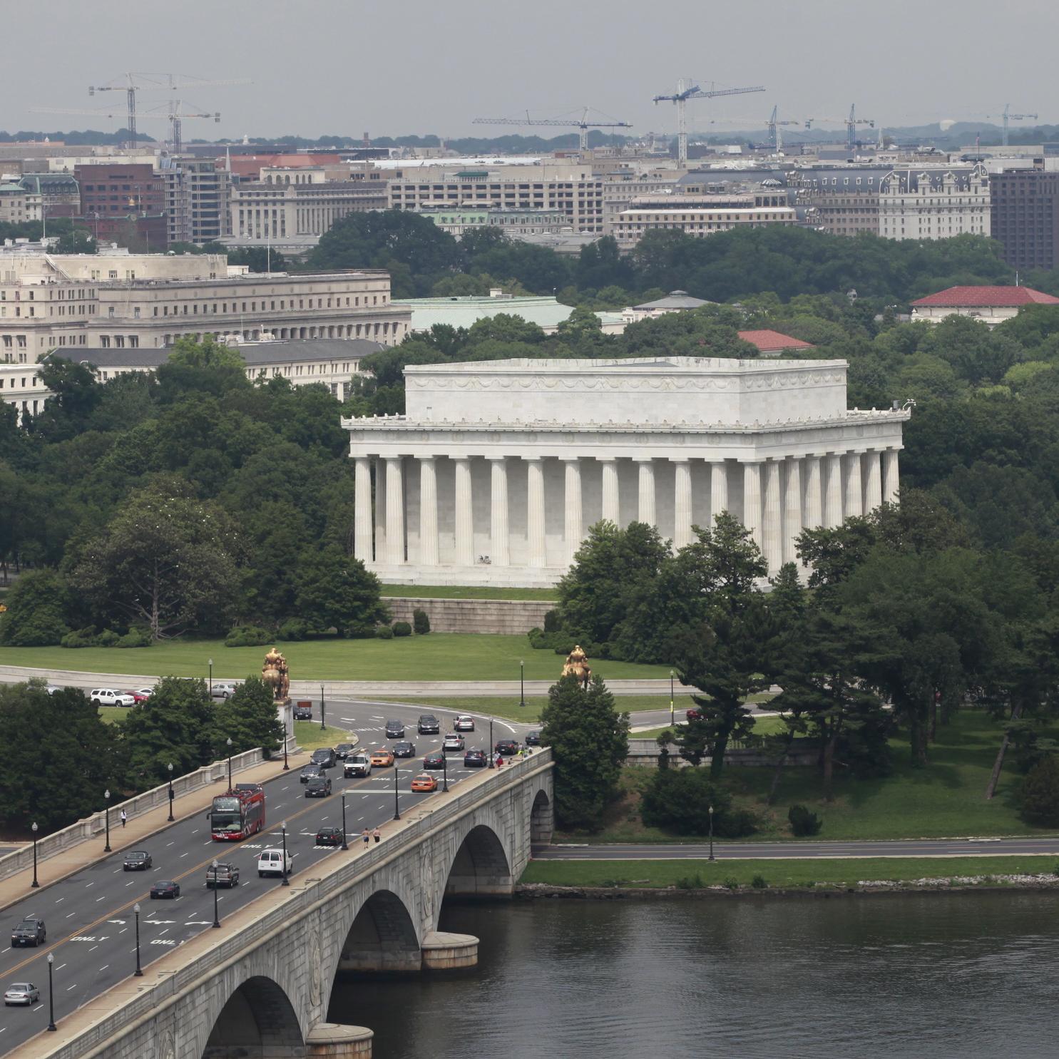 A bridge with cars connects to a large traffic circle around the Lincoln Memorial.