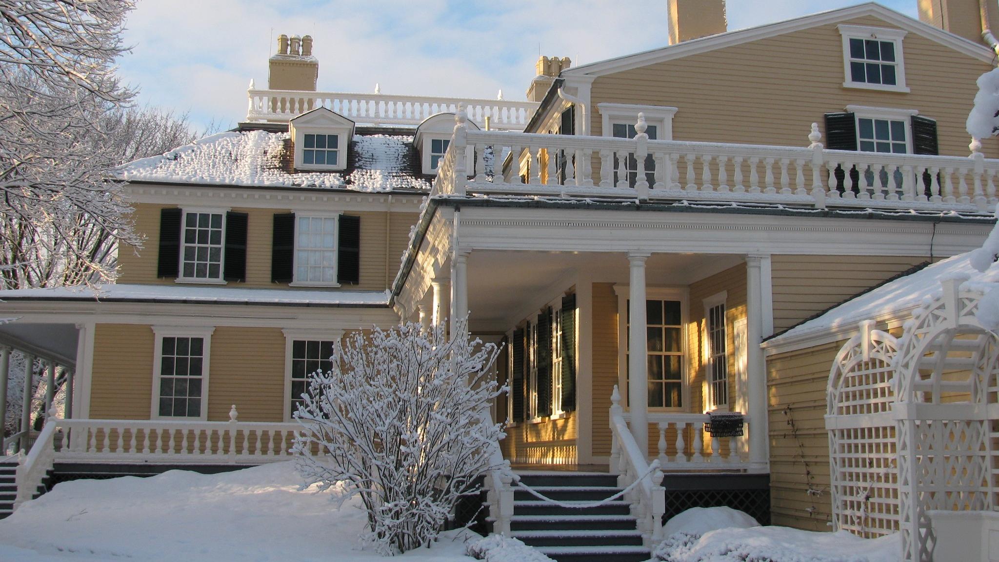 An exterior view of the Longfellow House with snow during winter.